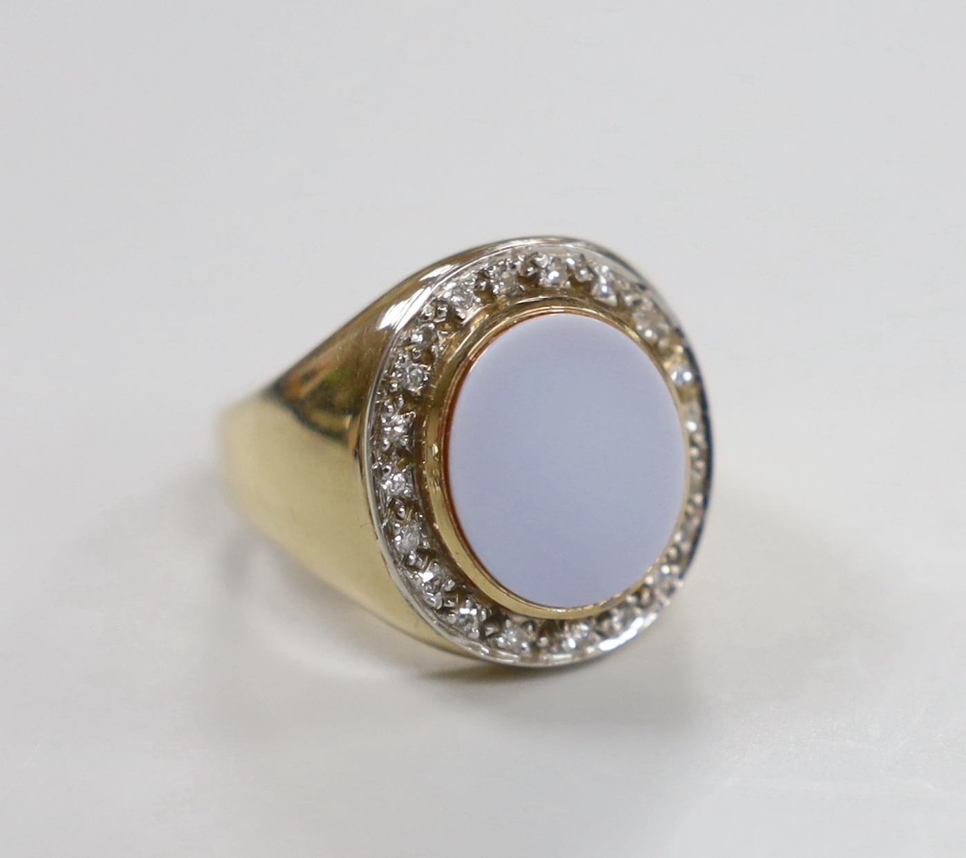 A modern 9ct gold and white carnelian set oval dress ring, with diamond chip set border, size R, gross weight 17.1 grams.